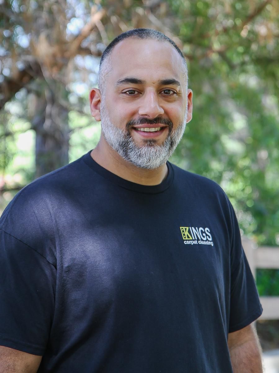 A vacuum cleaner is sitting on the floor next to a bed in a bedroom.