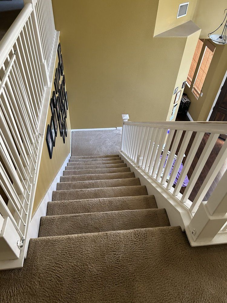The stairs are carpeted and have a white railing.