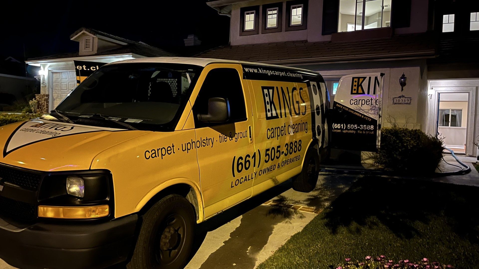 A yellow van is parked in front of a house at night