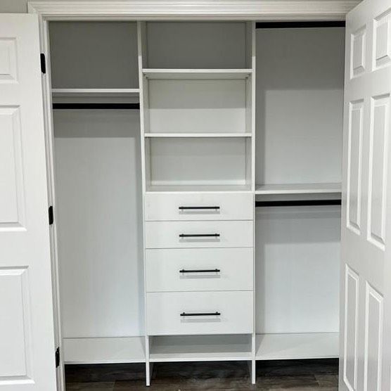 White closet organizer with shelves, drawers, and rods, between two white doors.