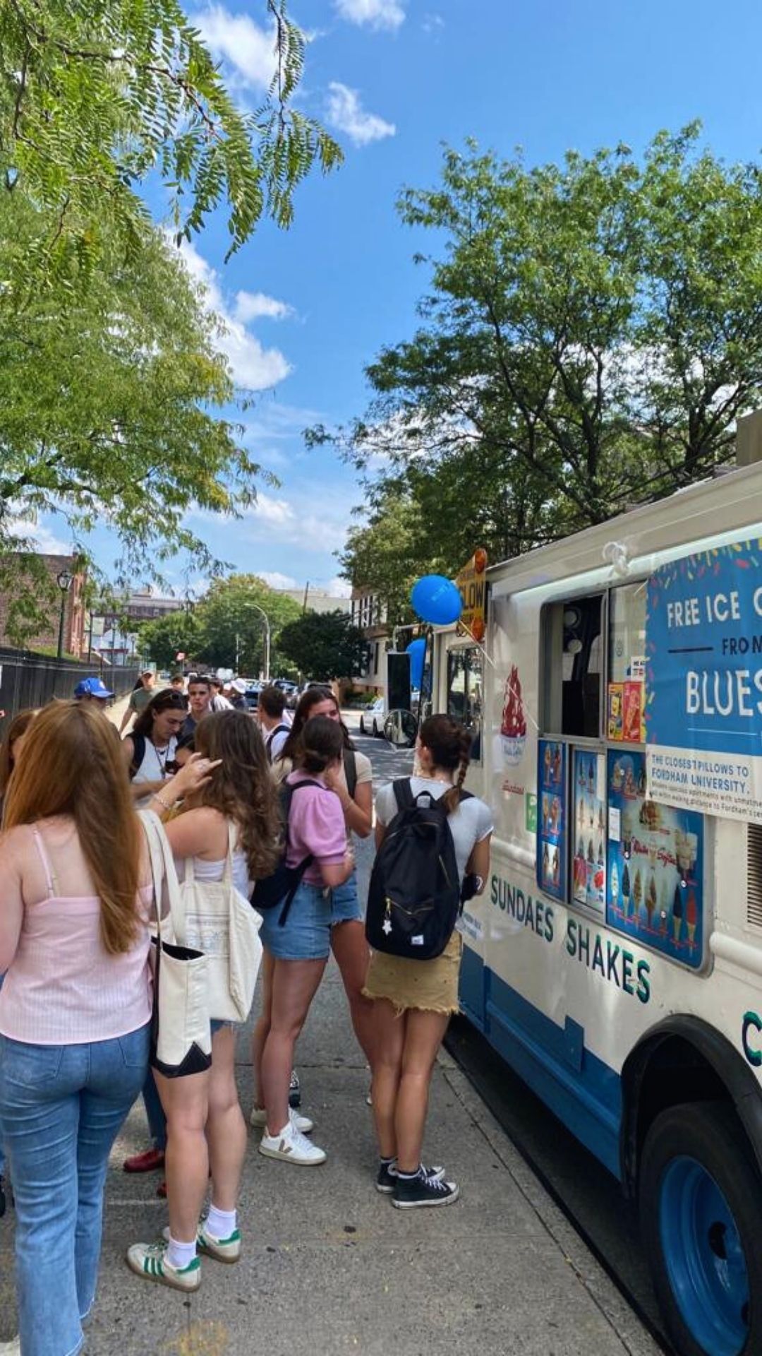 A group of people are standing in front of an ice cream truck.