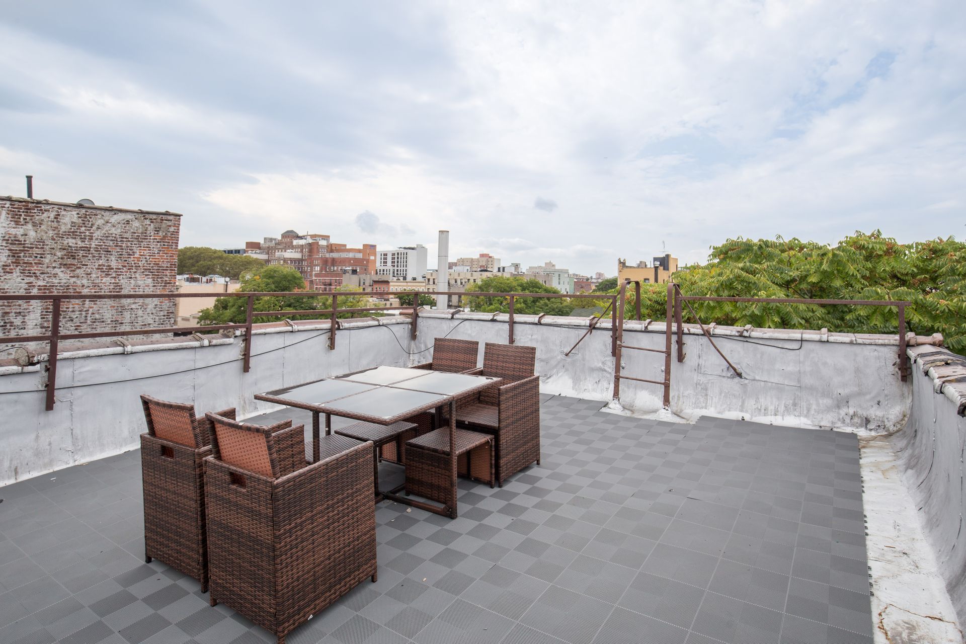 A rooftop with a table and chairs on it