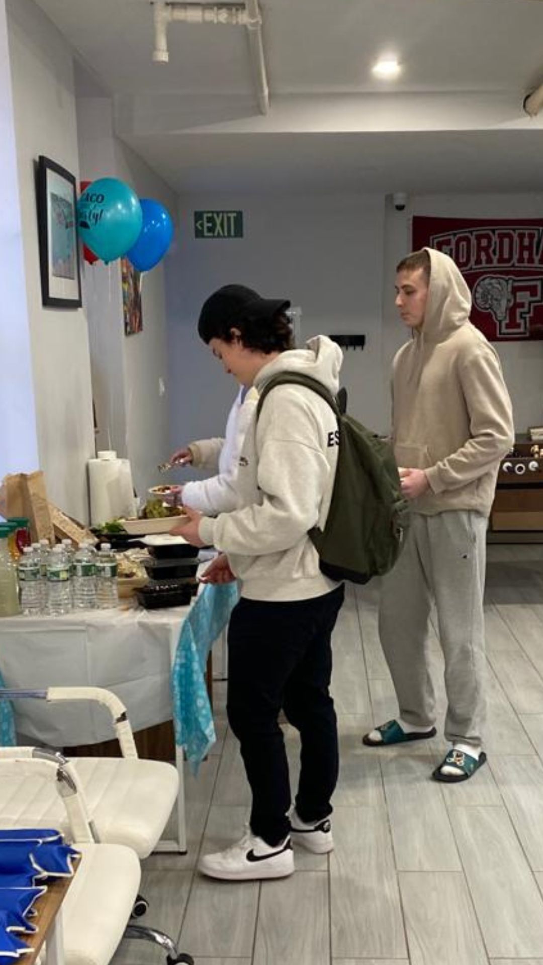 A group of young men are standing around a table in a room.
