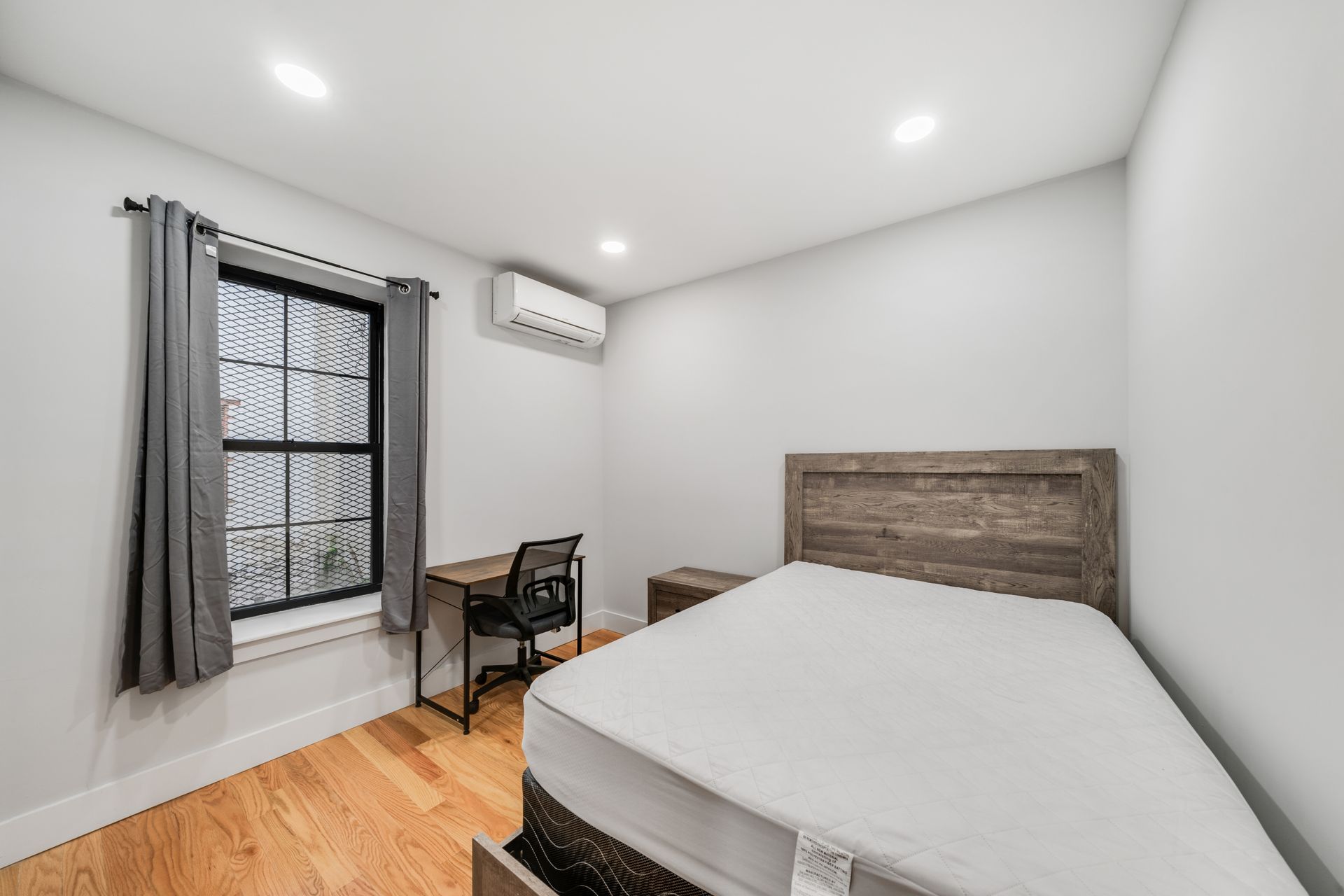 A bedroom with a bed , desk , chair and window.