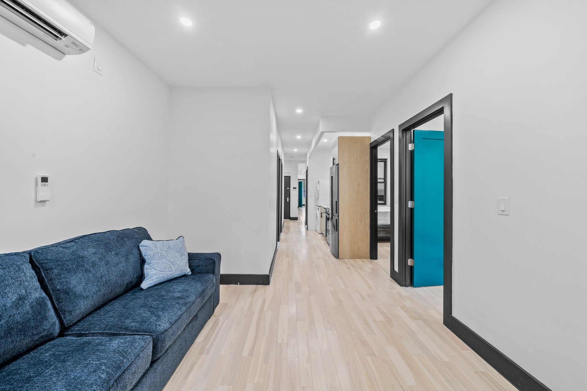 A living room with a blue couch and a blue door.