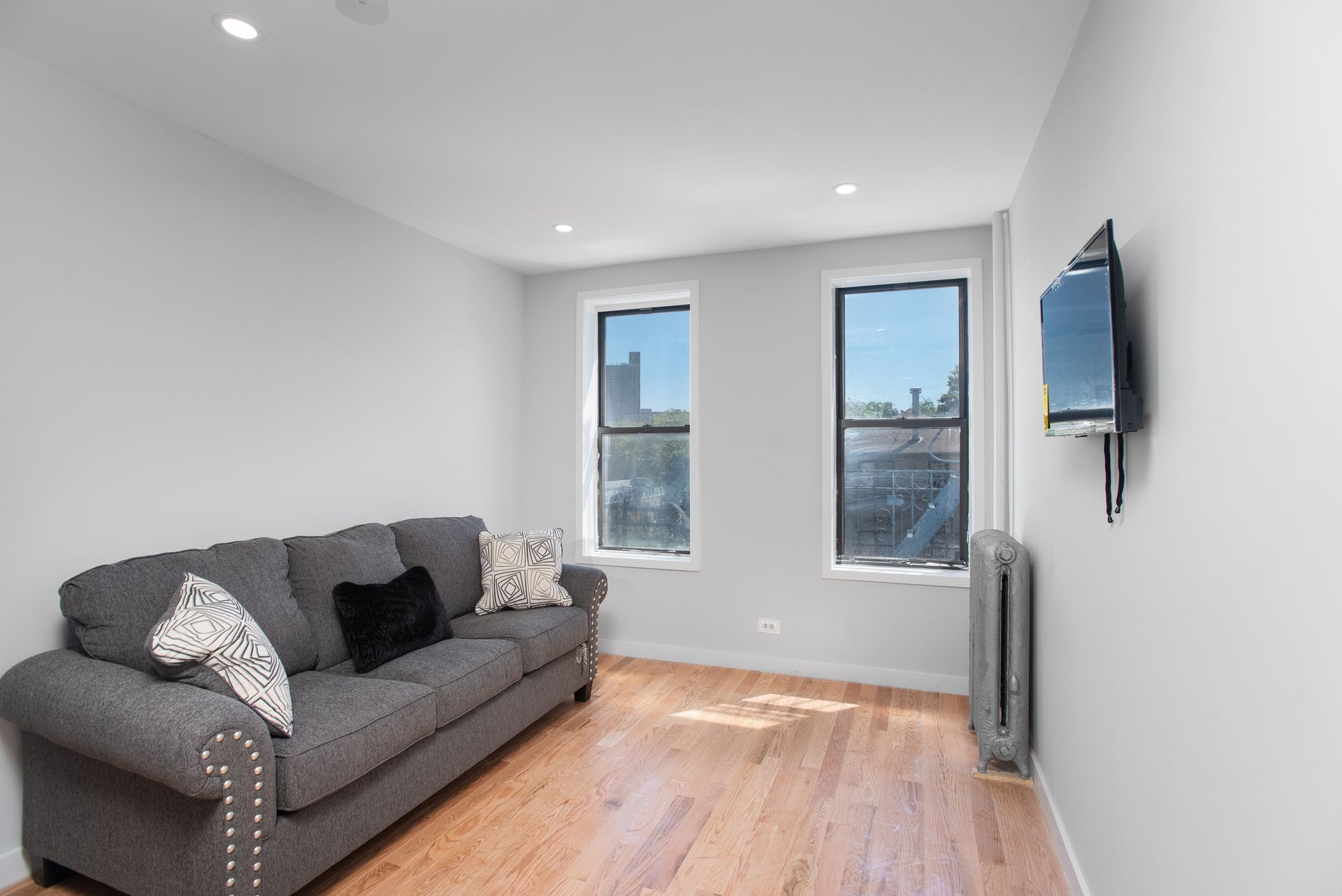 A living room with a couch and a television on the wall