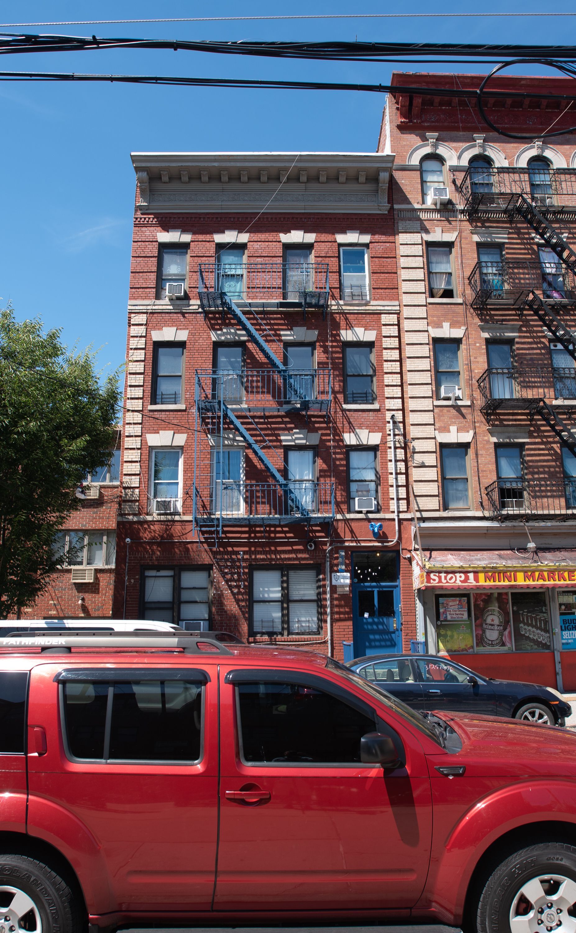 A red suv is parked in front of a brick building