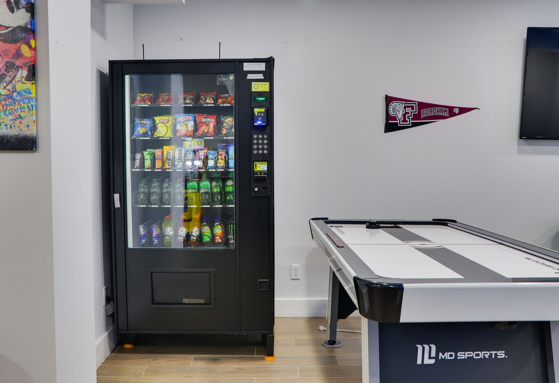 A game room with a pool table and a vending machine