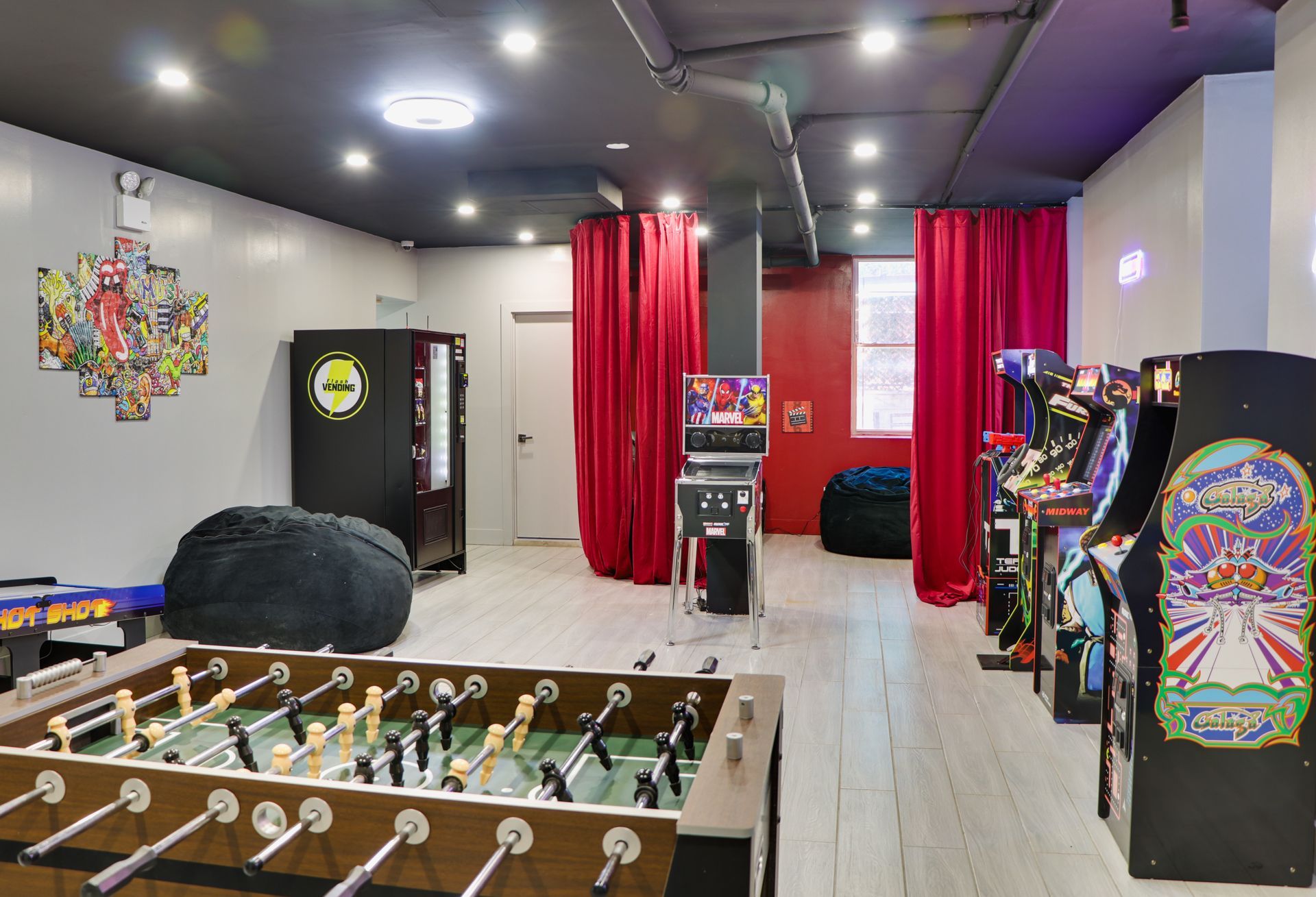 A game room with a foosball table and arcade games.