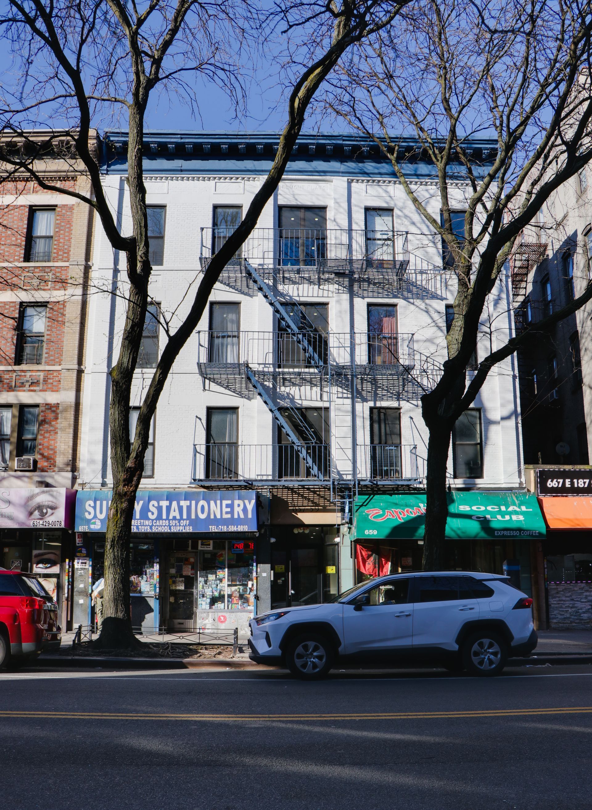 A white suv is parked in front of a stationery store