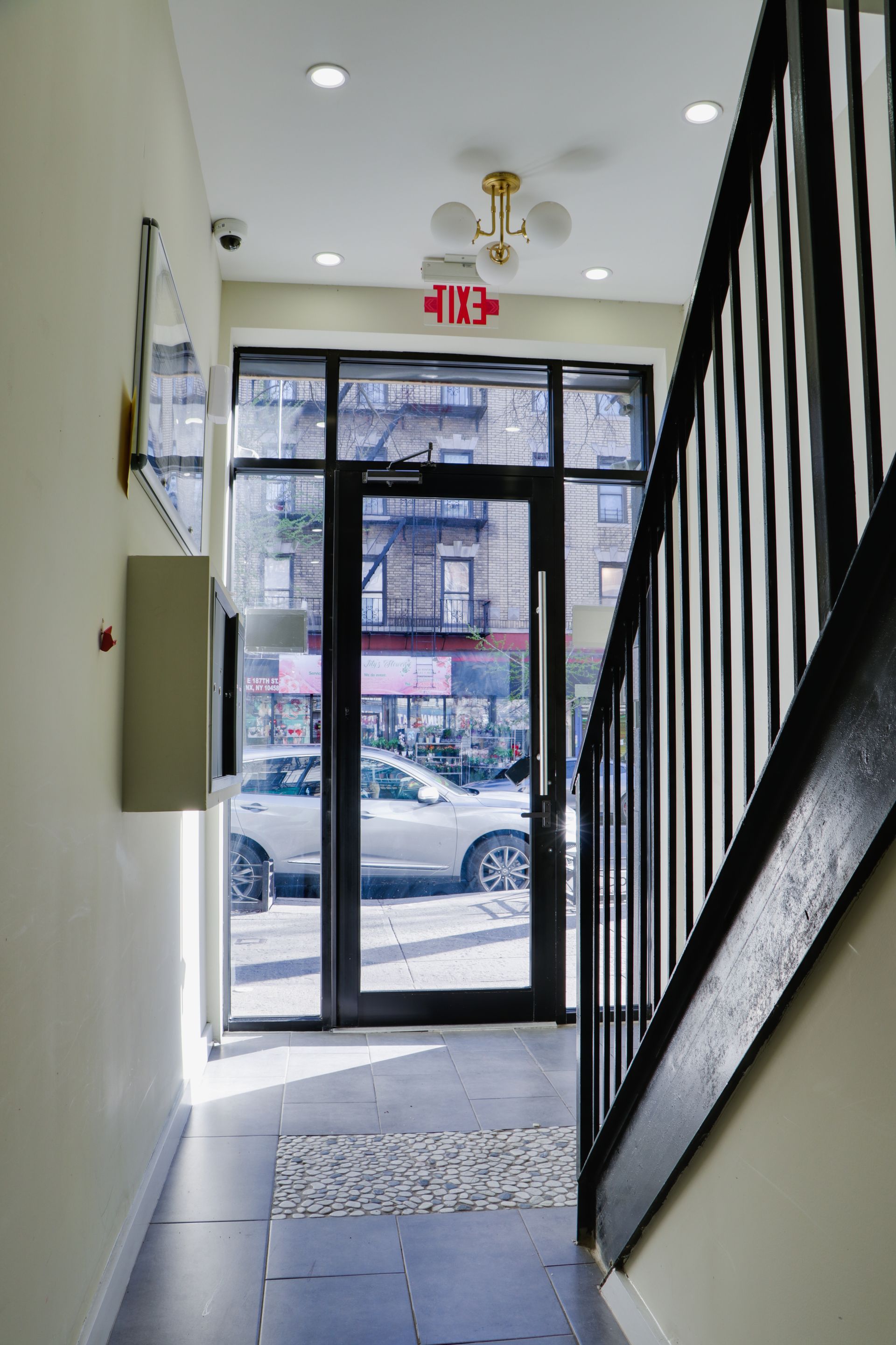 A hallway with a red exit sign above the door