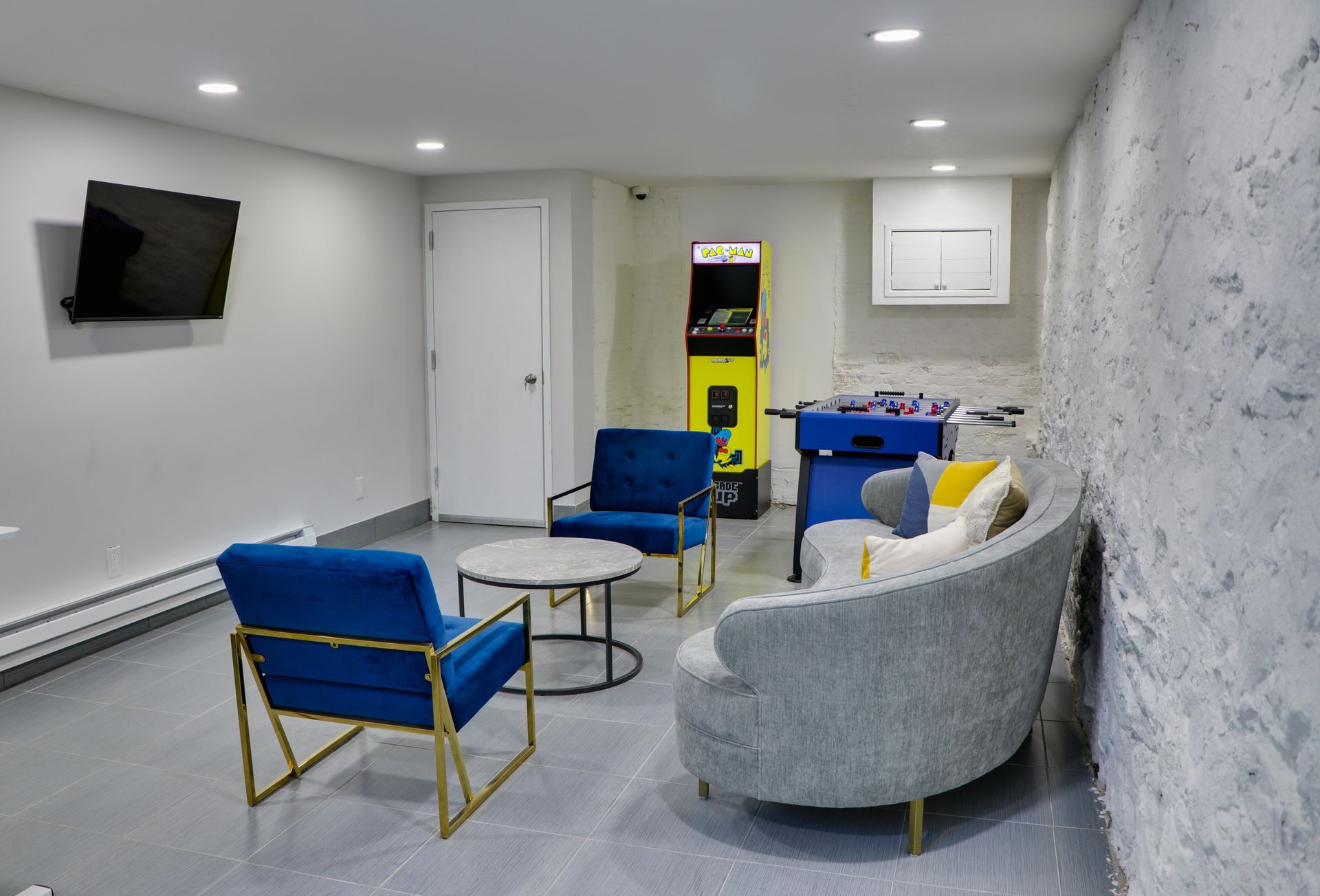 A living room with a couch , chairs , a table and a television.