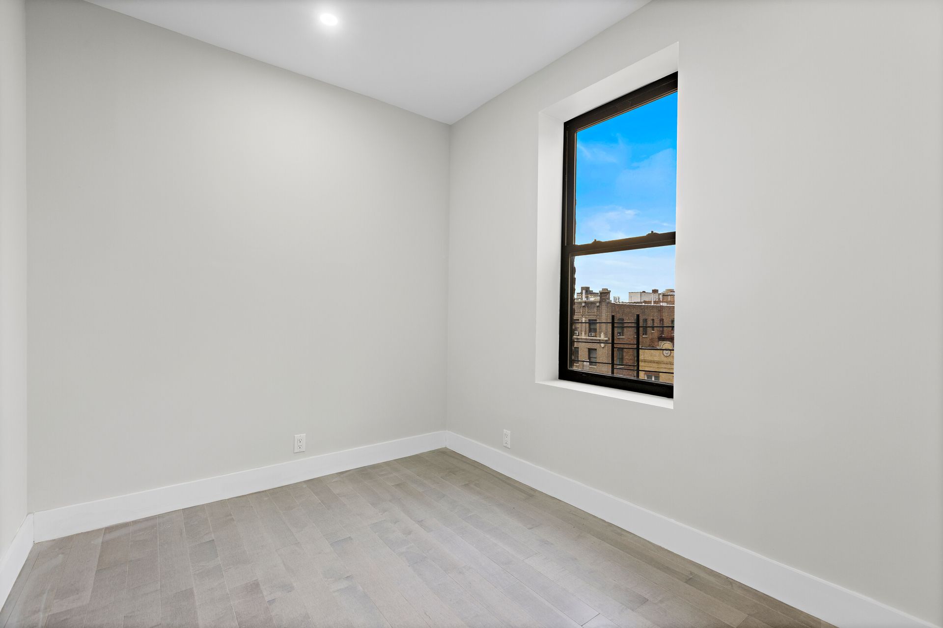 An empty room with a window and a view of a city.