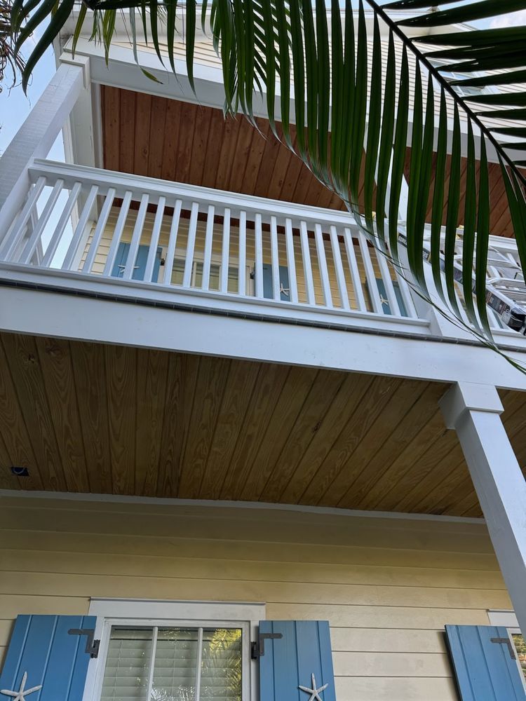 Looking up at a house with a balcony and blue shutters.
