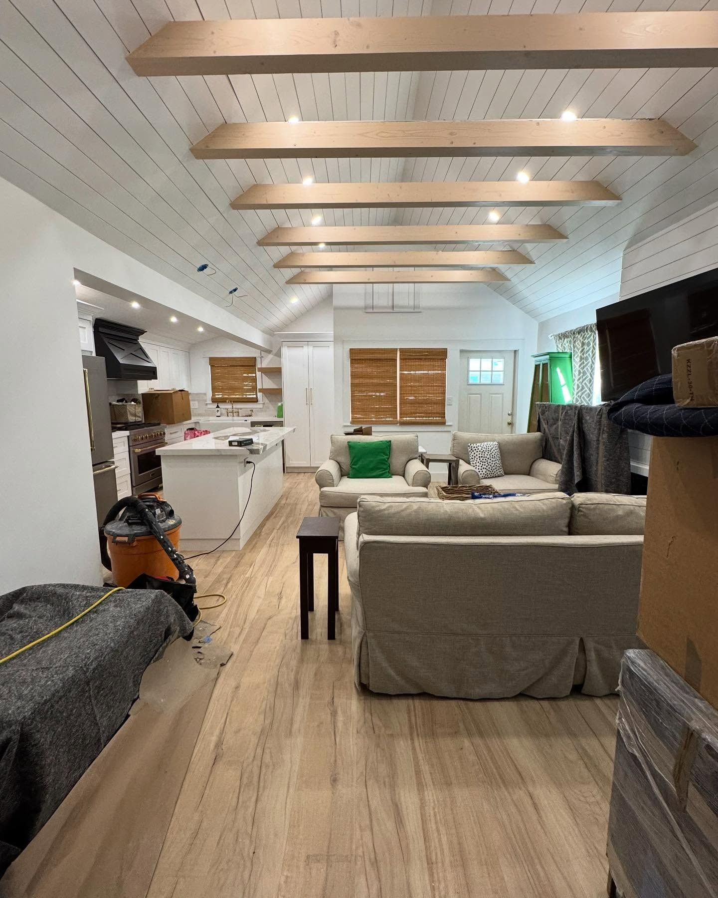 A living room with a couch and a vacuum cleaner in it