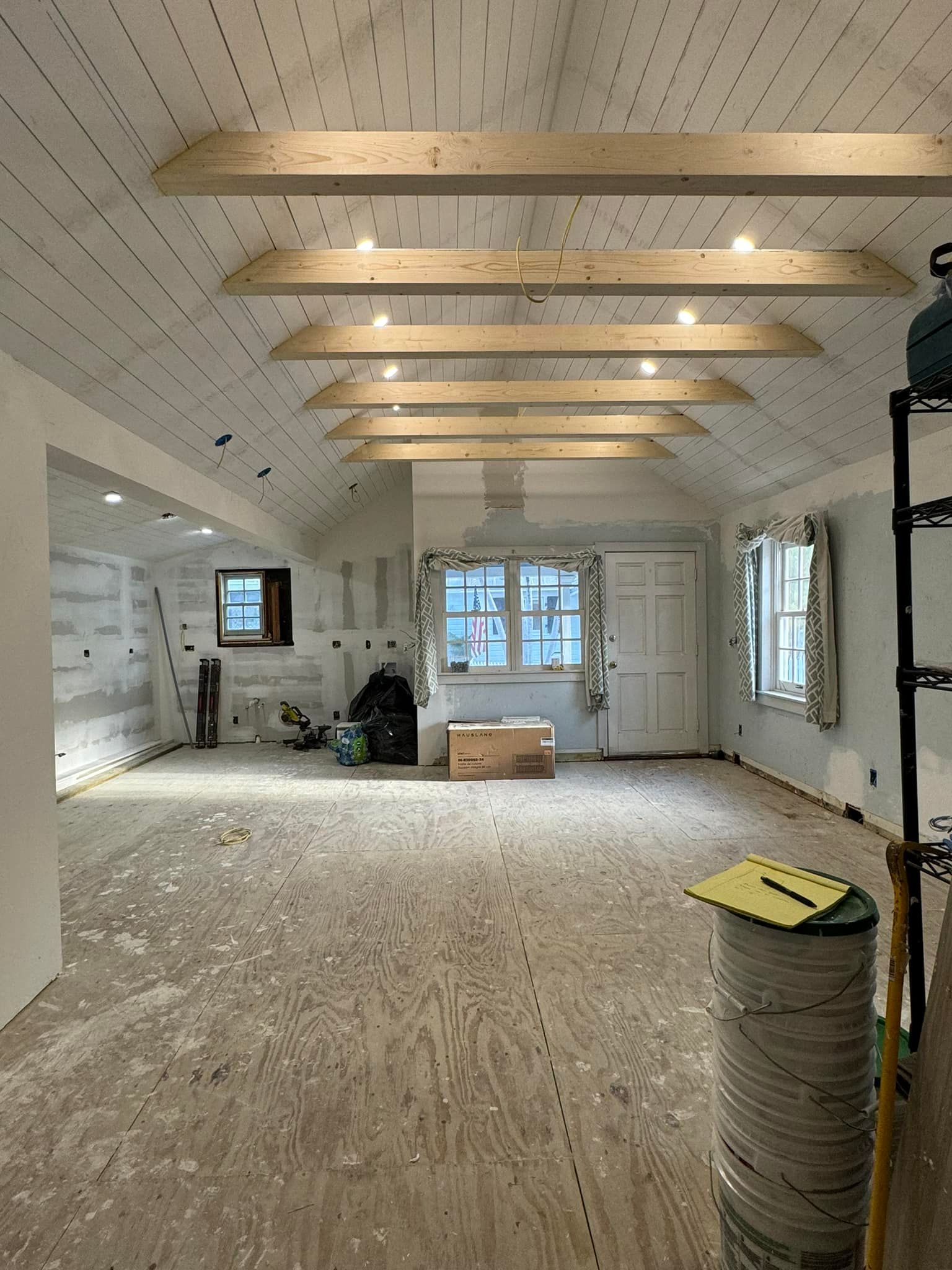 A large empty room with wooden beams on the ceiling.