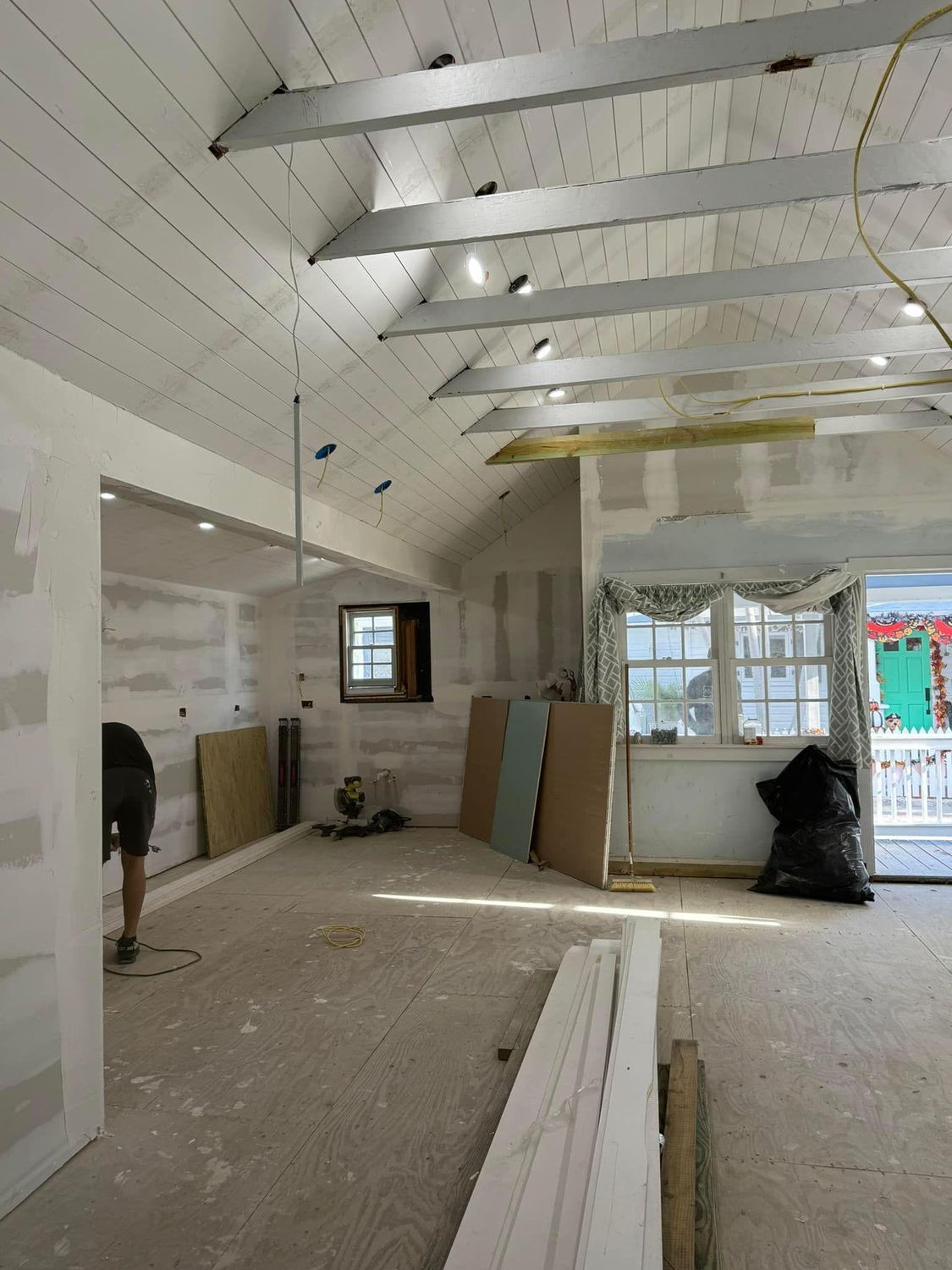 An empty room with a white ceiling and wooden beams