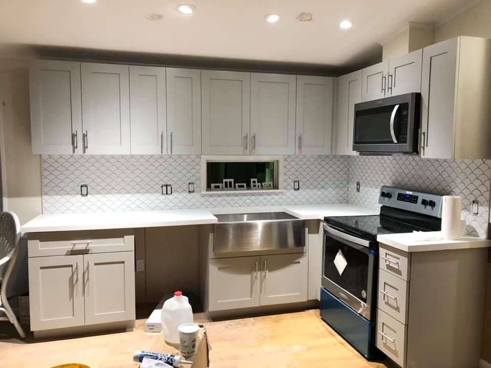 A kitchen with white cabinets and stainless steel appliances