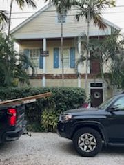 A black truck is parked in front of a house.