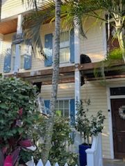A yellow house with blue shutters and a white picket fence.