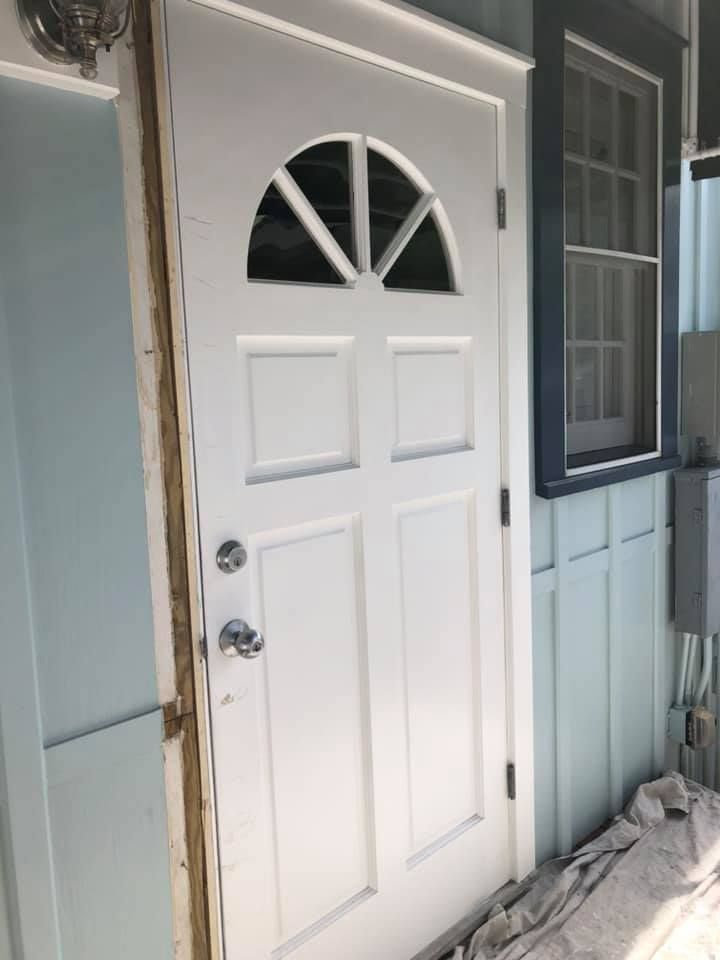A white door with a window on the side of a house.