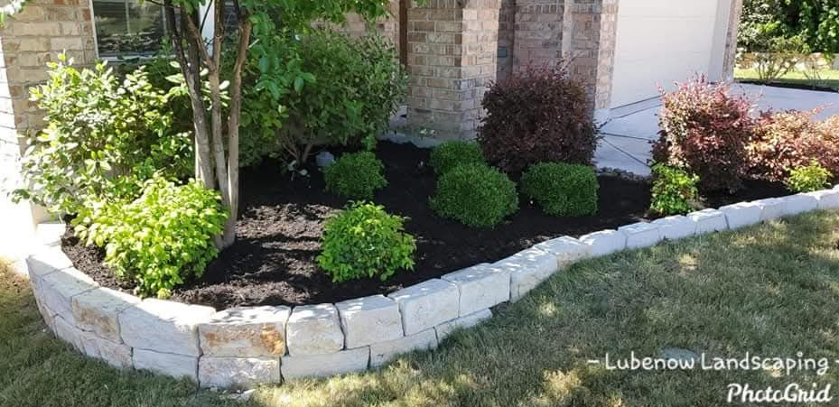 Backyard with dry grass, a brick patio, trees, and a wooden fence on the left