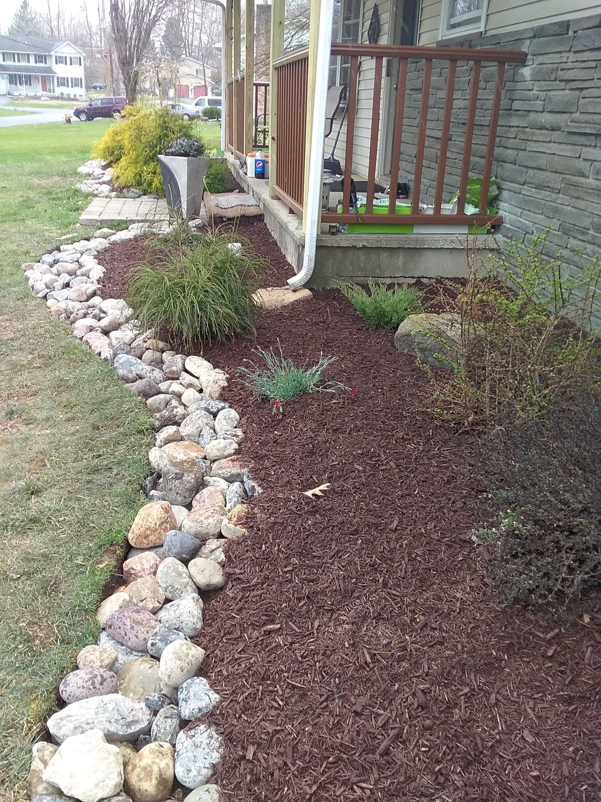 A stone walkway leading to a porch of a house.