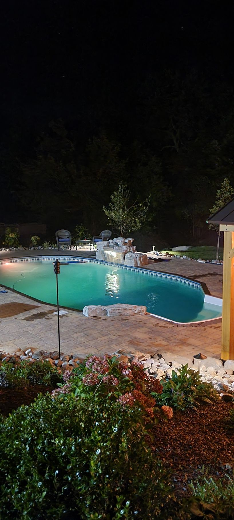 a large swimming pool is lit up at night .