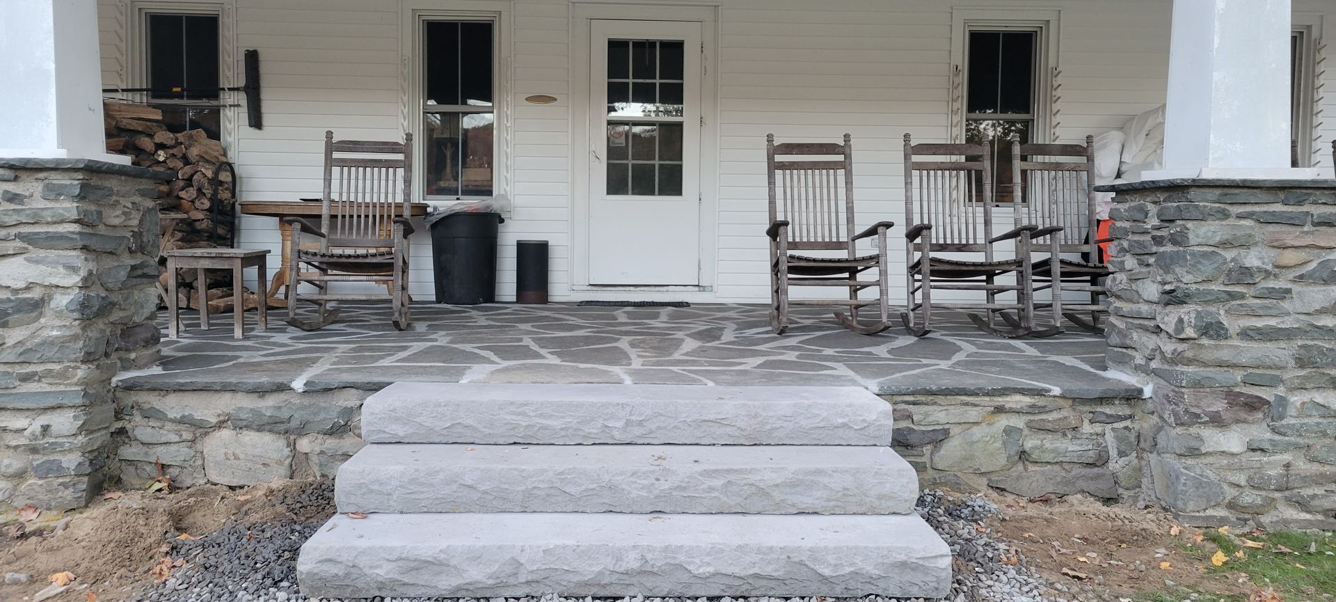 There are rocking chairs on the porch of a house.