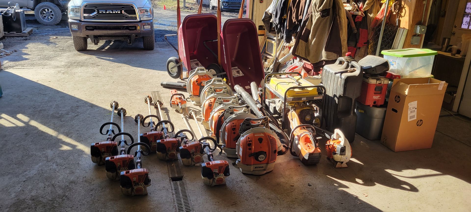 a bunch of lawn mowers are sitting in a garage .