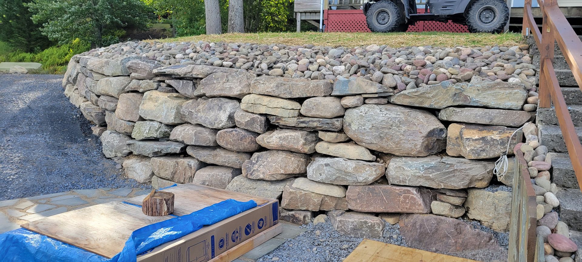 A large stone wall is being built in front of a house.