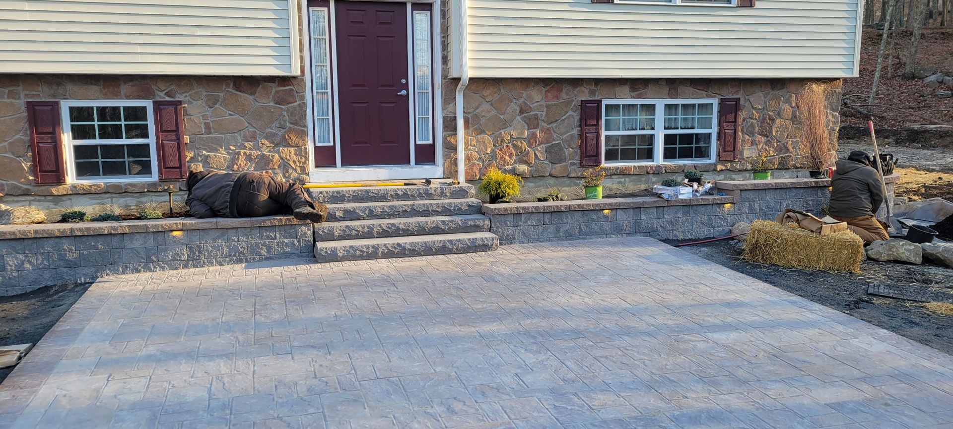 A brick house with a concrete driveway in front of it.