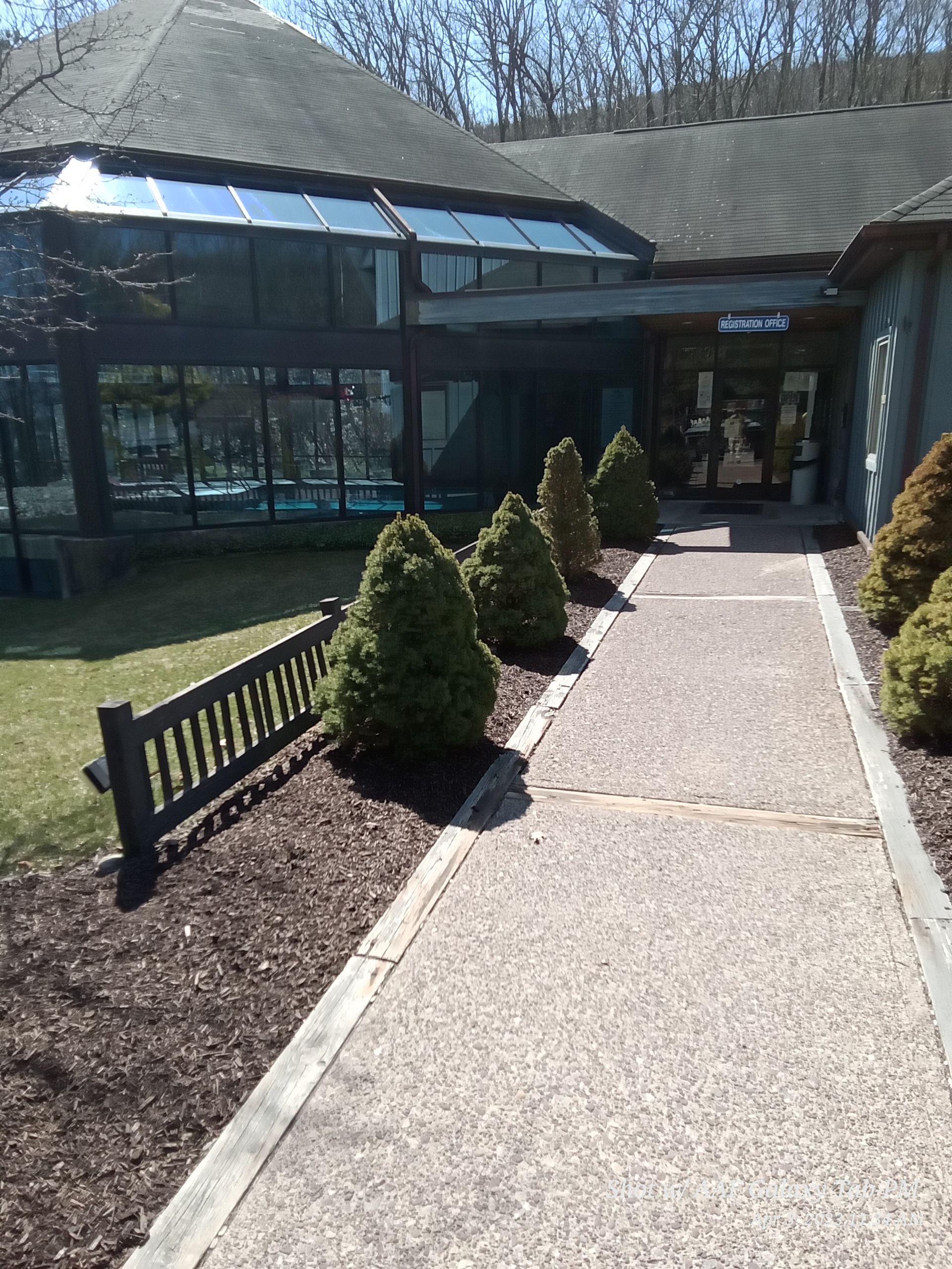 a walkway leading to a building with a bench in front of it .