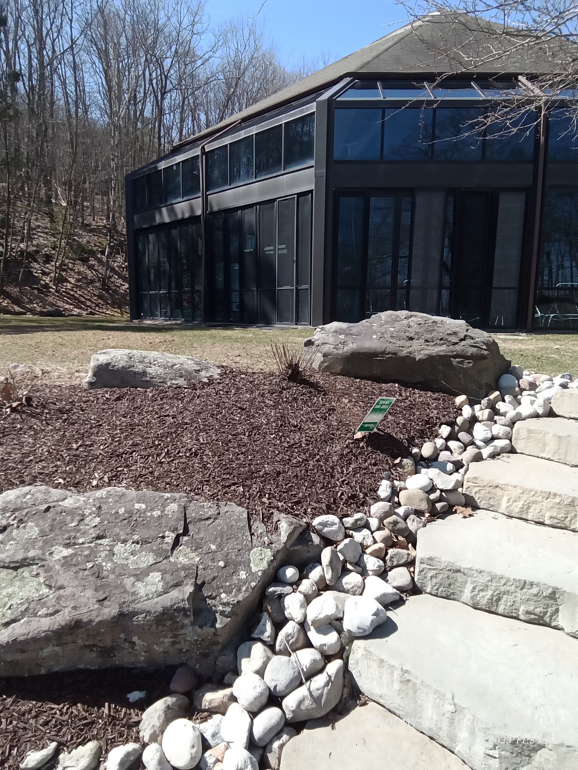 A large building with a lot of windows is surrounded by rocks and steps.