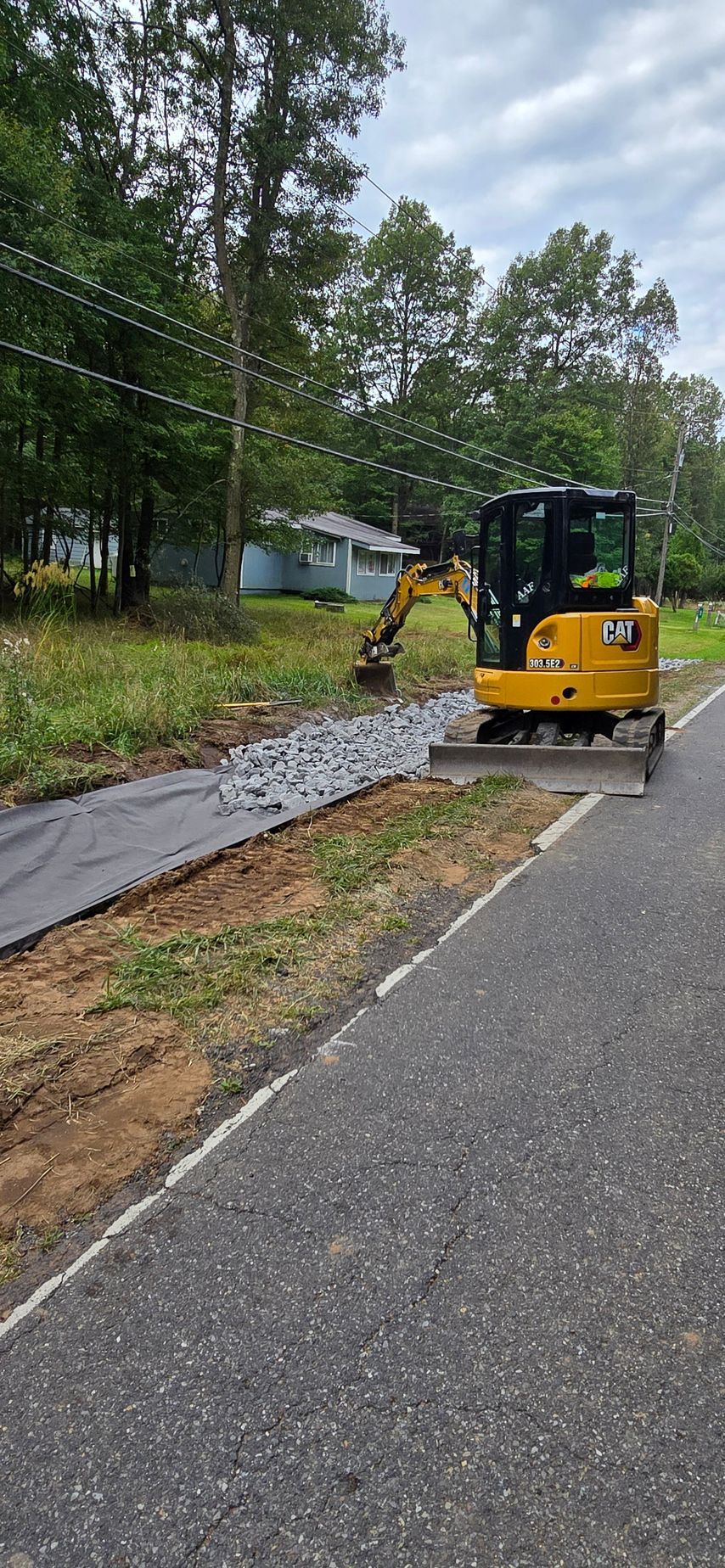 Excavator working on stone wall by A.A.F Landscaping