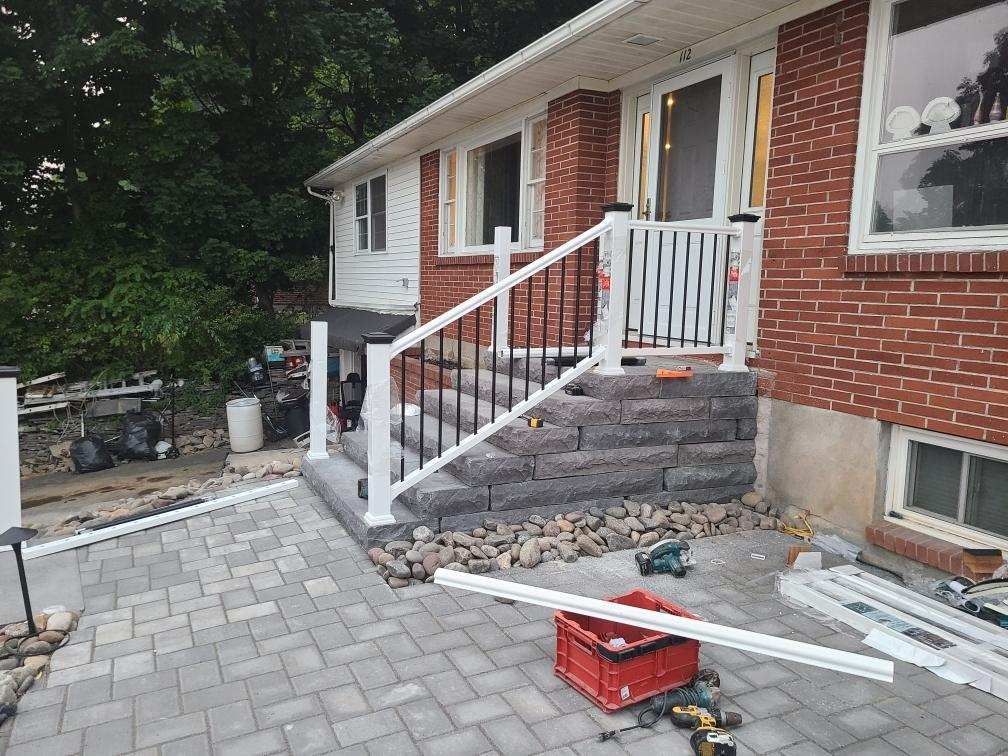 a brick house with a porch and stairs being built .