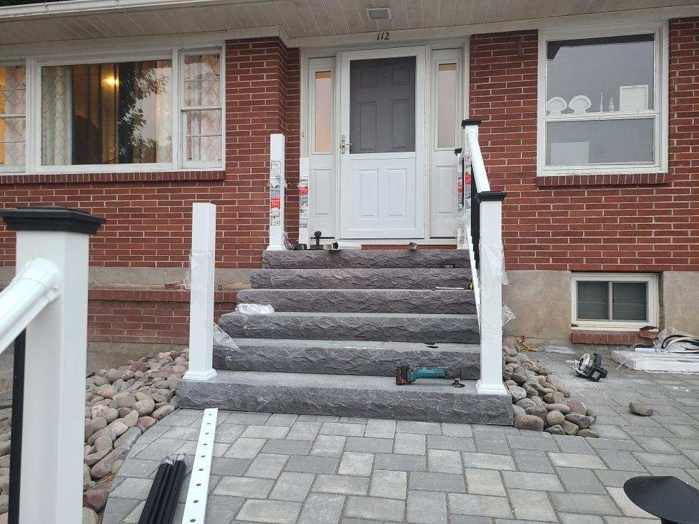a brick house with stairs and a white railing