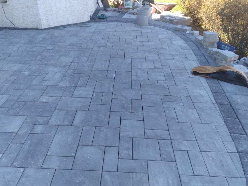 A brick walkway is being built in front of a building.