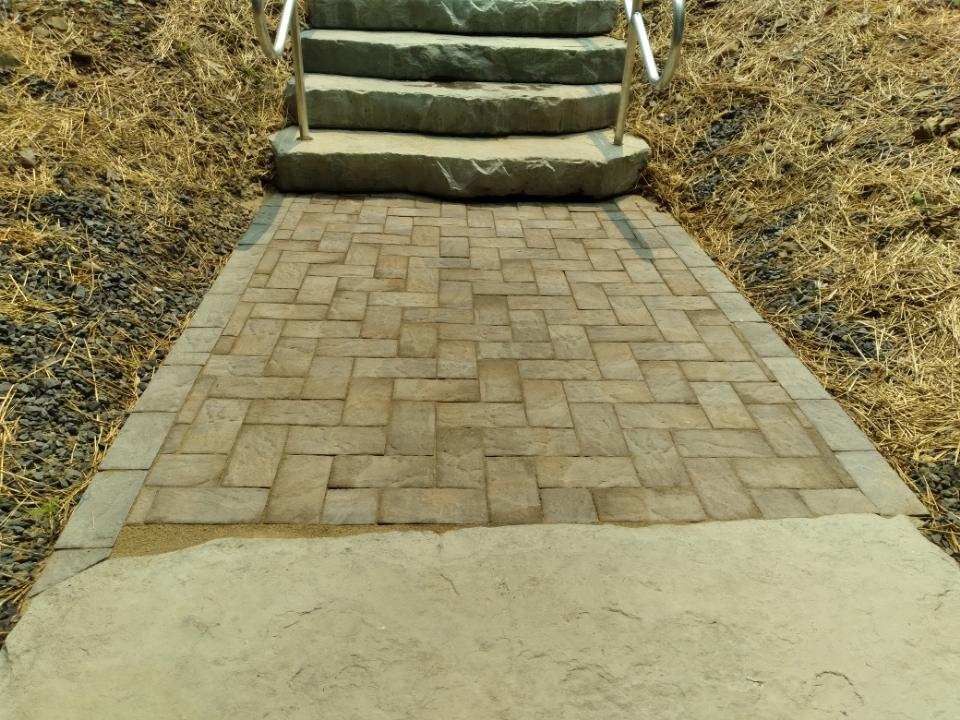A brick walkway leading up to a set of stairs