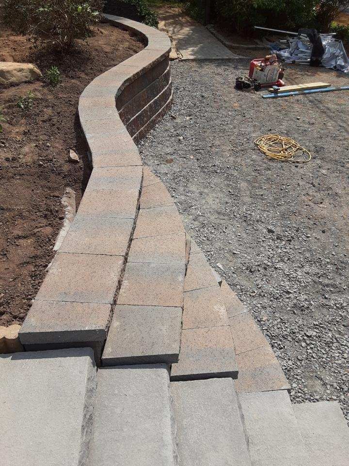 A brick wall is being built next to a set of stairs.