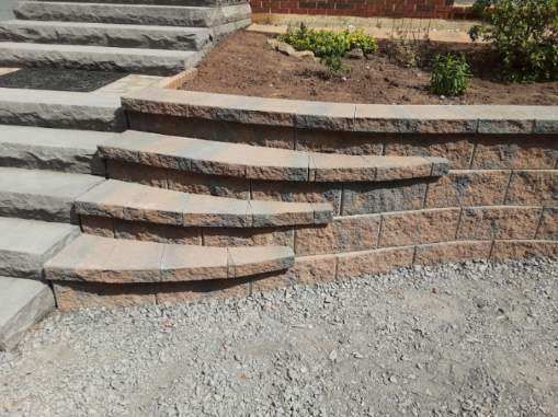 Stone steps and retaining wall with brown and gray blocks.