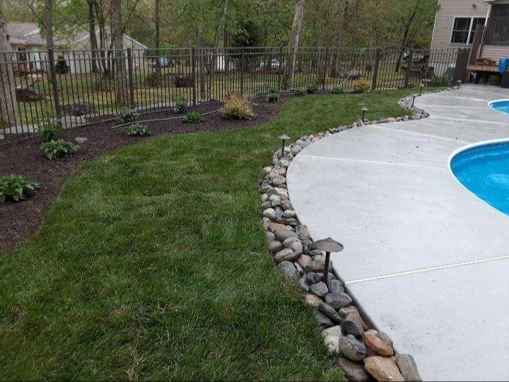 a swimming pool is surrounded by a lush green lawn