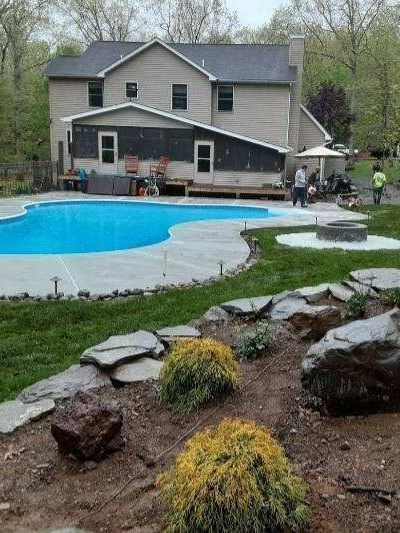 a large house with a large swimming pool in the backyard and landscaping done by A.A.F Landscaping