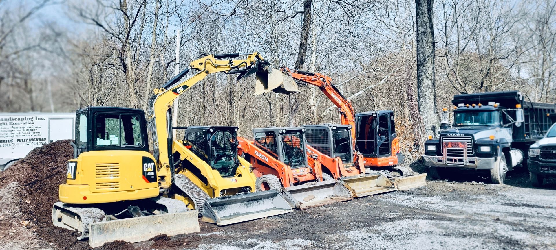a group of construction vehicles are parked next to each other in a parking lot .