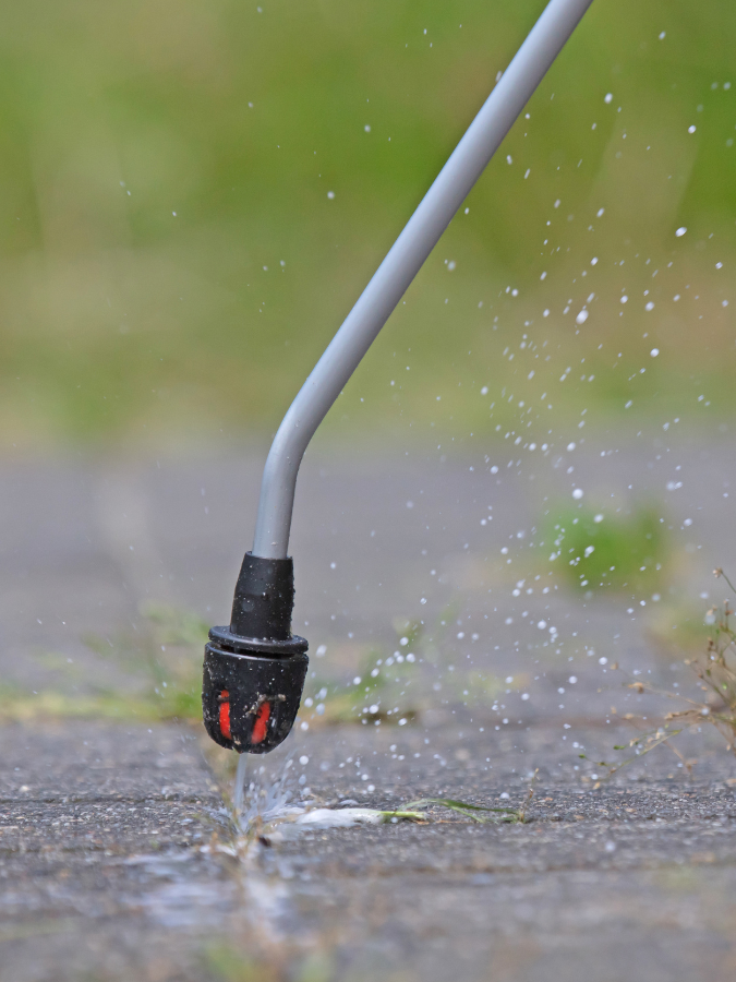 A sprayer is spraying water on a concrete surface.