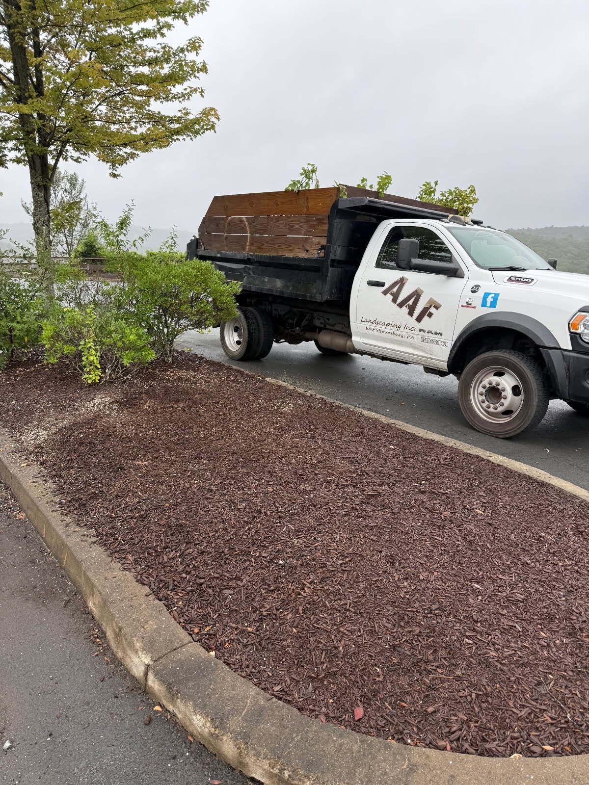 A truck is towing a bulldozer down a snowy road.