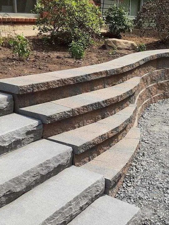 A set of stairs leading up to a stone wall.