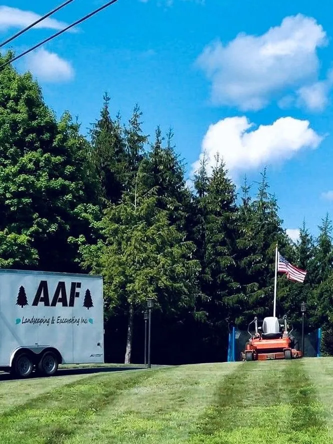 A white aaf truck is parked in a lush green field