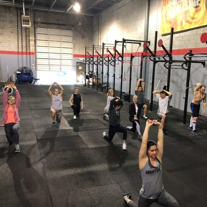 A group of people are doing stretching exercises at CrossFit Garage gym in Woodstock, GA