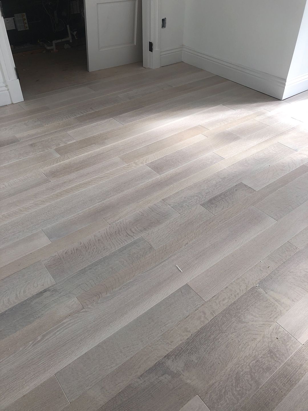 A room with a wooden floor and white walls.